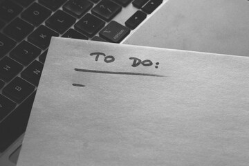 Komputer i kartka z lista zadań "to do". Praca i biznesowy klimat