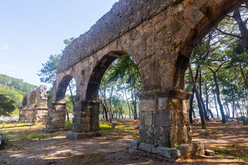 Fototapeta premium Ruins of aquaeduct in ancient city Phaselis, Antalya Province, Turkey. Lycian ancient civilization heritage.