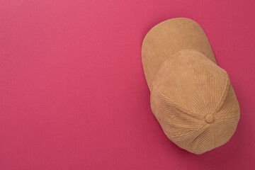 Beige velvet cap on color background, top view