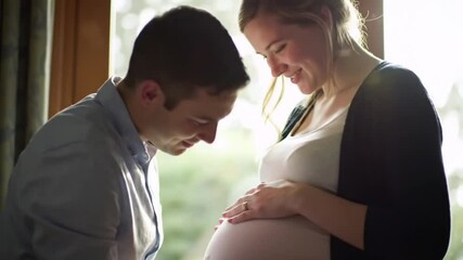 pregnant woman with her husband, Young happy couple man kiss on her wife belly video, pregnant woman, happy pregnant woman video, happy young couple, man kisses his wife belly video, ai generated - Powered by Adobe