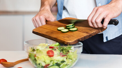 Little Daughter Cooking With Daddy Making Vegetable Salad For Dinner Standing In Kitchen At Home. Cropped