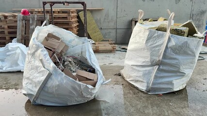 Two large bags filled with cardboard waste at the construction site serve to highlight significant efforts in recycling