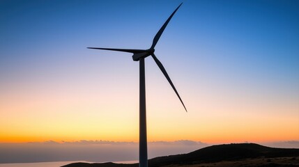 Obraz premium Serene sunset over coastal hills with silhouette of a wind turbine creating a peaceful and sustainable landscape