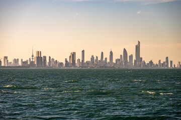 Obraz premium City Skyline with Liberation Tower and Modern Skyscrapers Viewed from the Arabian Gulf at Sunset – Kuwait