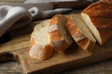 Pieces of fresh baguette on wooden table, closeup