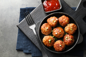 Tasty meatballs served on grey table, flat lay