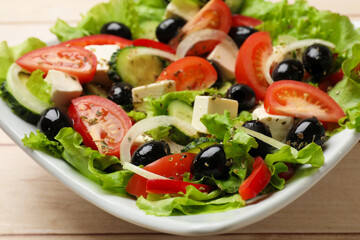 Delicious fresh Greek salad on white wooden table, closeup