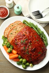 Delicious baked turkey meatloaf with vegetables served on wooden table, flat lay