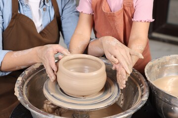 Hobby and craft. Mother with her daughter making pottery indoors, closeup