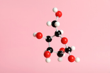 Molecule of glucose on pink background. Chemical model