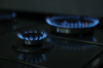 Gas burners with blue flame on stove, closeup