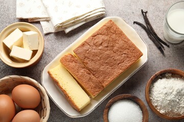 Tasty Japanese Castella sponge cake and ingredients on light table, flat lay