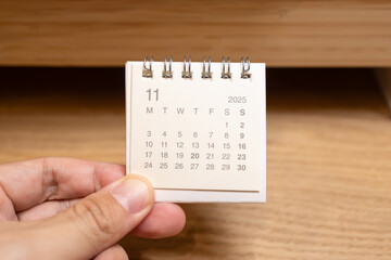 Desk Calendar for NOVEMBER 2025 background. Calendar concept with 2025 NOV calendar on wooden...