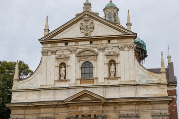 Baroque Church Facade with Sculptures, Ornate Decorations, and a Historic Dome in a European City