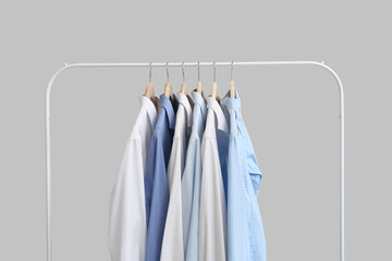 Obraz premium Rack with stylish collar shirts on grey background