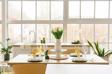 Dining table set for Easter with tulips in kitchen