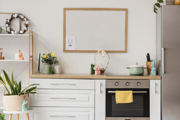 Interior of kitchen decorated for Easter with counters and blank frame