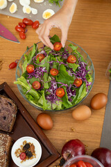 A beautiful, fresh salad featuring crisp lettuce, sweet cherry tomatoes, and vibrant red cabbage, perfectly arranged in a bowl, ready to be savored and enjoyed.

