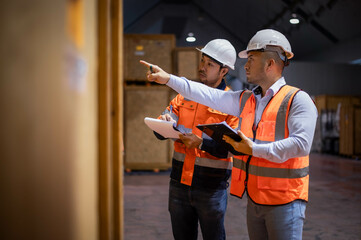 Warehouse inspectors and expert engineers are checking the arrangement of goods to ensure that they are in accordance with the planned plans.