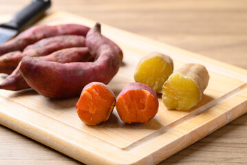 Orange and yellow sweet potato on  cutting wooden board