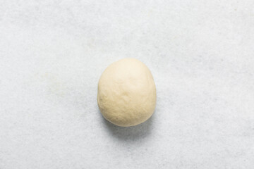 Overhead view of doughnut dough on a white countertop, top view of doughnut dough on a white background, process of making doughnut