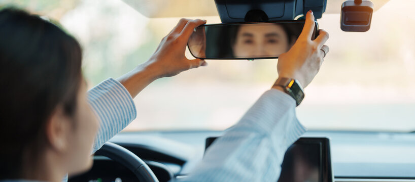 Business woman driver adjusting rear view mirror a car. Journey, trip and safety Transportation concepts