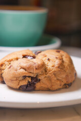 Freshly baked cookie served with a cup of coffee in cozy setting