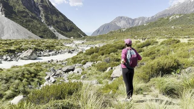 portrait of a smiling girl enjoying the wonderful alpine views on the hooker valley track in Mount cook national park, south island,New Zealand. Most popular trail on south island