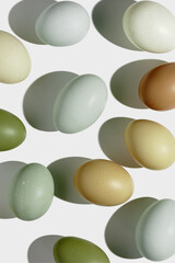 Top view natural easter Eggs with shadows on light background, minimal trend food pattern from assorted organic Chicken egg with neutral earth color eggshells, Easter food celebration