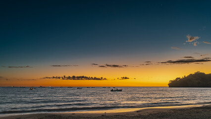 Evening after sunset on a tropical island. The blue sky is highlighted with orange near the...