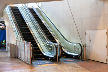 Escalators leading up to the upper level in a modern indoor space with minima design and bright...