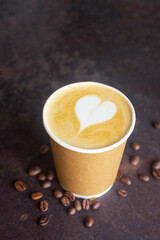 hot latte coffee in takeaway paper coffee cup, ready to go coffee on brow rustic table.
