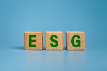 ESG letter symbol on wooden blocks isolated on blue background. concept of environmental and sustainability government responsibility