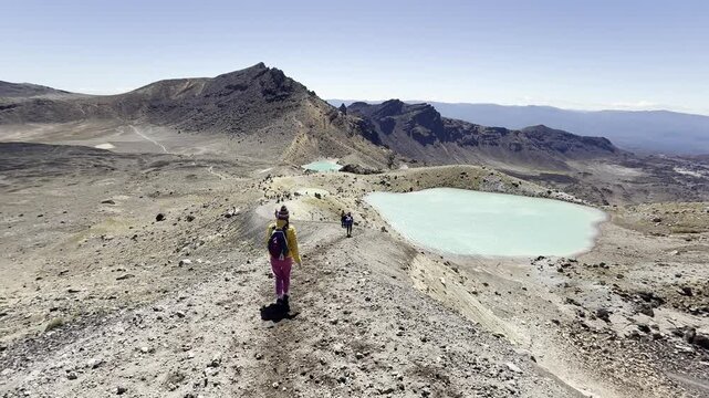 Brave hiker girl descends to famous Emerald lakes on Tongariro Alpine Crossing. New Zealand's oldest and most popular park, Tongariro National Park, North Island, NZ