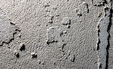 A wall with a rough texture and a few holes