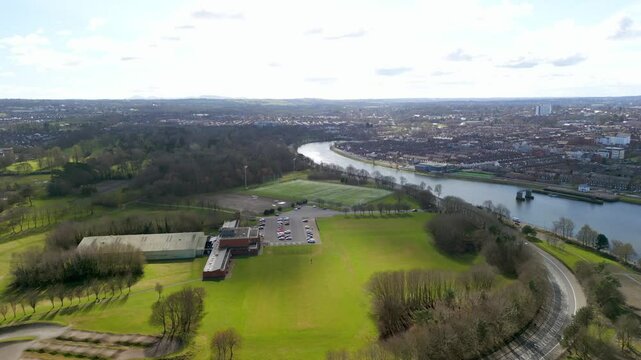 Aerial of Belfast City in the sunshine on a bright Spring day. Th camera passes forwards, over Ormeau Park and the River Lagan. Produced in 4K, in 60 frames per second and in Rec709 color.