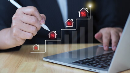 Real Estate Market Growth with Rising Interest Rates concept. Close-up of a person writing on a...