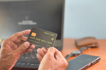 A person holding a fake credit card against a work desk background