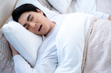 ベッドで眠る日本人男性
