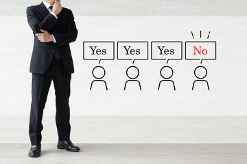 メンバーの意見や考えが合わずに困るスーツを着た男性