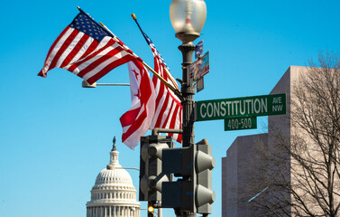 The Capitol building near Constitution street. The Constitution as symbol of the America. The Capitol dome on Constitution sign. Washington, D.C. U.S. Constitution and U.S. government.