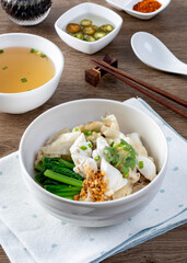 chinese egg noodle in bowl with slice red roasted pork, pork's wontons and white crab meat on it.