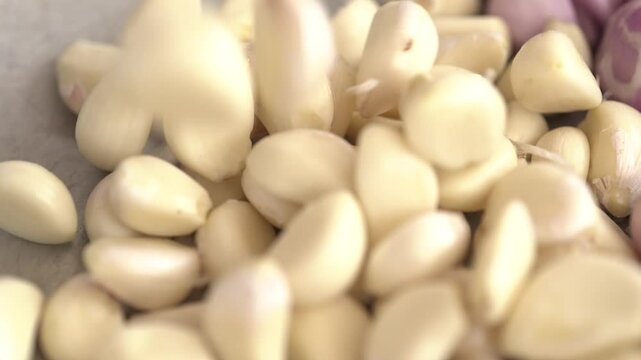 Close-up of fresh peeled garlic cloves placed in a glass bowl. Commonly used in basic recipes that are nutritious and healthy.