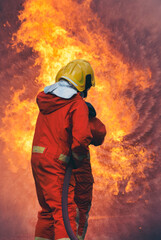 Obraz premium Vertical Horizon Firefighter Rescue training in fire fighting extinguisher. Firefighter fighting with flame use fire hose chemical water foam spray engine. Vertical Fireman wear hard hat safety suit