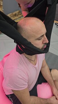 Doctor performing cervical spine traction therapy on patient