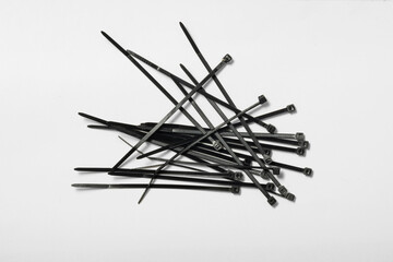 Collection of black cable ties scattered on a flat surface