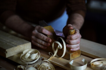 Plane jointer carpenter or joiner tool and wood shavings. Woodworking tools on wooden table. Carpentry workshop