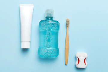Mouthwash and other oral hygiene products on colored table top view with copy space. Flat lay....