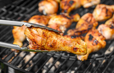 Kucharz przekracza złocistego kurczaka na drugą stroną na rozgrzanym ruszcie, grillowanie w ogrodzie  © Paweł Kacperek