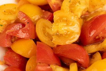 sliced ripe tomatoes of red and yellow color during salad preparation